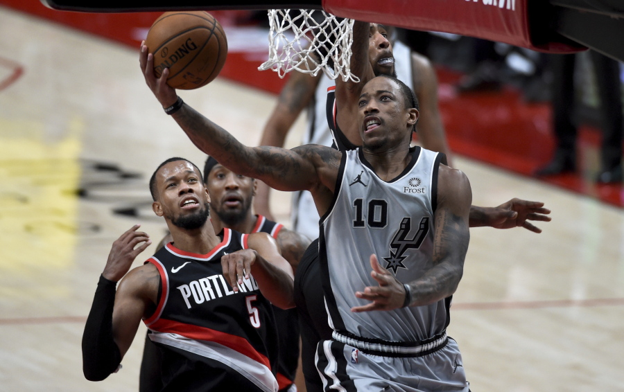 San Antonio Spurs forward DeMar DeRozan, right, drives to the basket on Portland Trail Blazers guard Rodney Hood, right, during the second half of an NBA basketball game in Portland, Ore., Monday, Jan. 18, 2021.