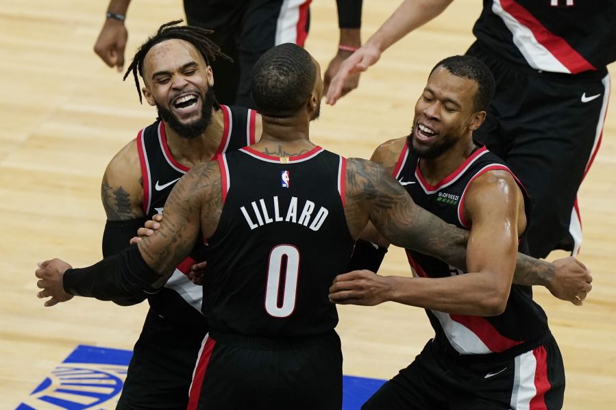Portland Trail Blazers guard Damian Lillard (0) celebrates with guards Gary Trent Jr., left, and Rodney Hood after making the winning three-point basket during the second half of an NBA basketball game against the Chicago Bulls in Chicago, Saturday, Jan. 30, 2021. (AP Photo/Nam Y.
