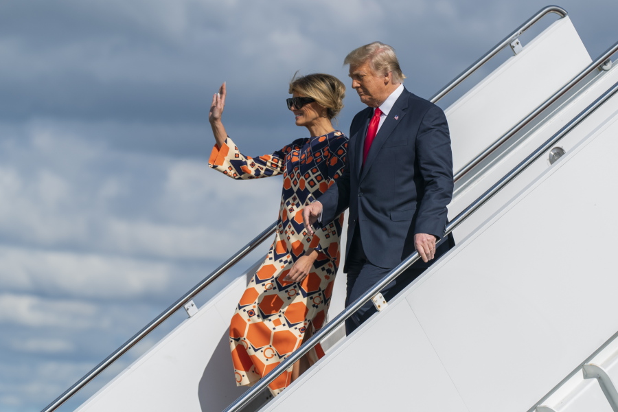 Former President Donald Trump and Melania Trump wave as they disembark from their final flight on Air Force One at Palm Beach International Airport in West Palm Beach, Fla., Wednesday, Jan. 20, 2021.