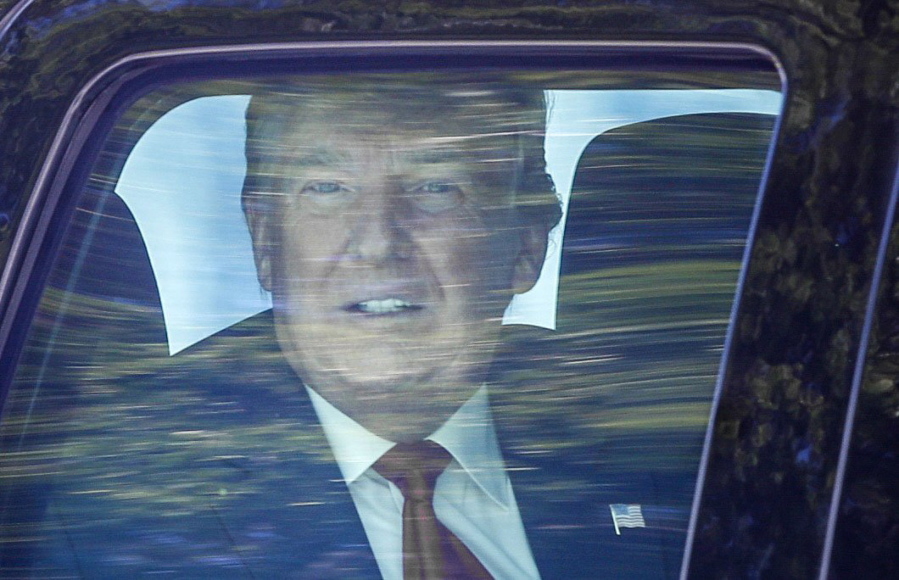 Former President Donald Trump looks out his window as his motorcade drives through West Palm Beach, Fla., on his way to his Mar-a-Lago club in Palm Beach after arriving from Washington aboard Air Force One on Wednesday, Jan. 20, 2021.