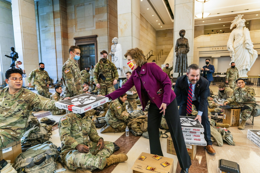 Rep. Vicky Hartzler, R-Mo., and Rep. Michael Waltz, R-Fla., hand pizzas to members of the National Guard gathered at the Capitol Visitor Center, Wednesday, Jan. 13, 2021, in Washington. as the House of Representatives continues with its fast-moving House vote to impeach President Donald Trump, a week after a mob of Trump supporters stormed the U.S. Capitol.