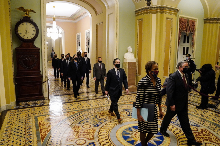 Clerk of the House Cheryl Johnson along with acting House Sergeant-at-Arms Tim Blodgett lead the Democratic House impeachment managers as they walk through the Capitol Hill to deliver to the Senate the article of impeachment alleging incitement of insurrection against former President Donald Trump, in Washington, Monday, Jan. 25, 2021.