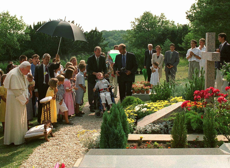 FILE - In this Aug.22, 1997 file photo, Pope John Paul II meditates by the grave of his former friend geneticist Jerome Lejeune, during a private visit to the Chalo-Saint-Mars cemetery near Paris. Pope Francis on Thursday, Jan. 21, 2021, approved the &quot;heroic virtues&quot; of Dr. Jerome Lejeune, who discovered the genetic basis of Down syndrome, lived from 1926-1994 and was particularly esteemed by St. John Paul II for his anti-abortion stance.