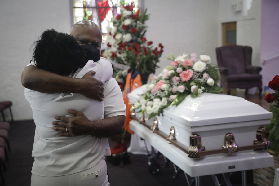 FILE - In this July 21, 2020, file photo, Darryl Hutchinson, facing camera, is hugged by a relative during a funeral service for Lydia Nunez, who was Hutchinson&#039;s cousin at the Metropolitan Baptist Church in Los Angeles. Nunez died from COVID-19. Southern California funeral homes are turning away bereaved families because they&#039;re running out of space for the bodies piling up during an unrelenting coronavirus surge.