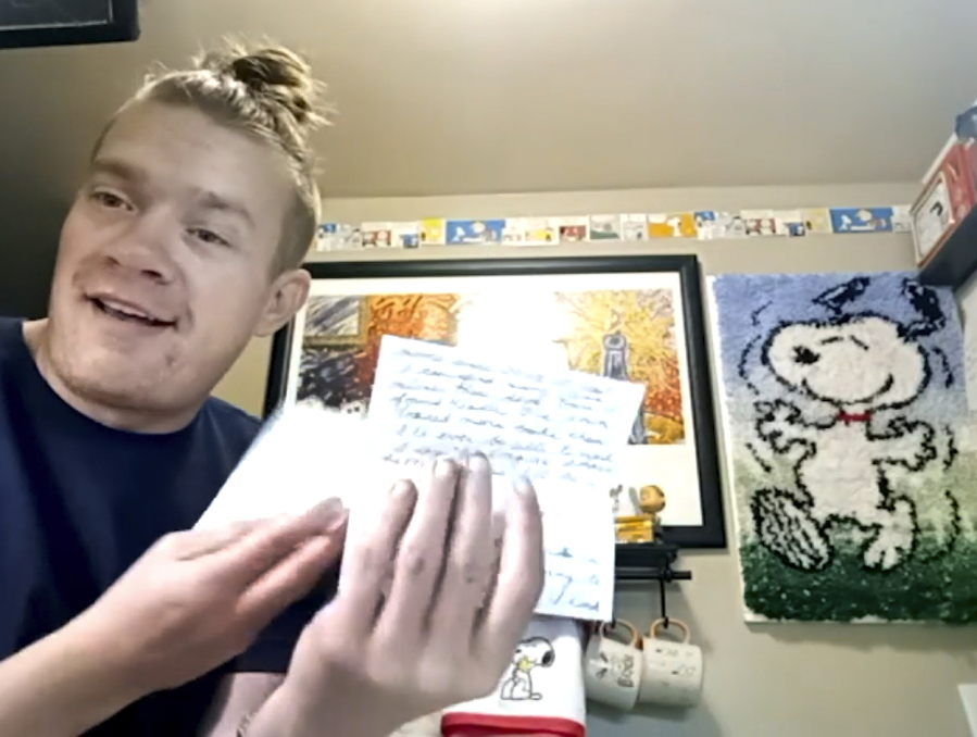 In this Dec. 20, 2020, still image taken from video, Wesley Morgan, a 32-year-old in Denver, shows a letter from one of his &quot;Peanuts&quot; pen pals. After being furloughed from his job at the Denver International Airport, Morgan began writing to over 500 older adults living in isolation due to the pandemic. He says 142 responded, and many have become consistent correspondents.