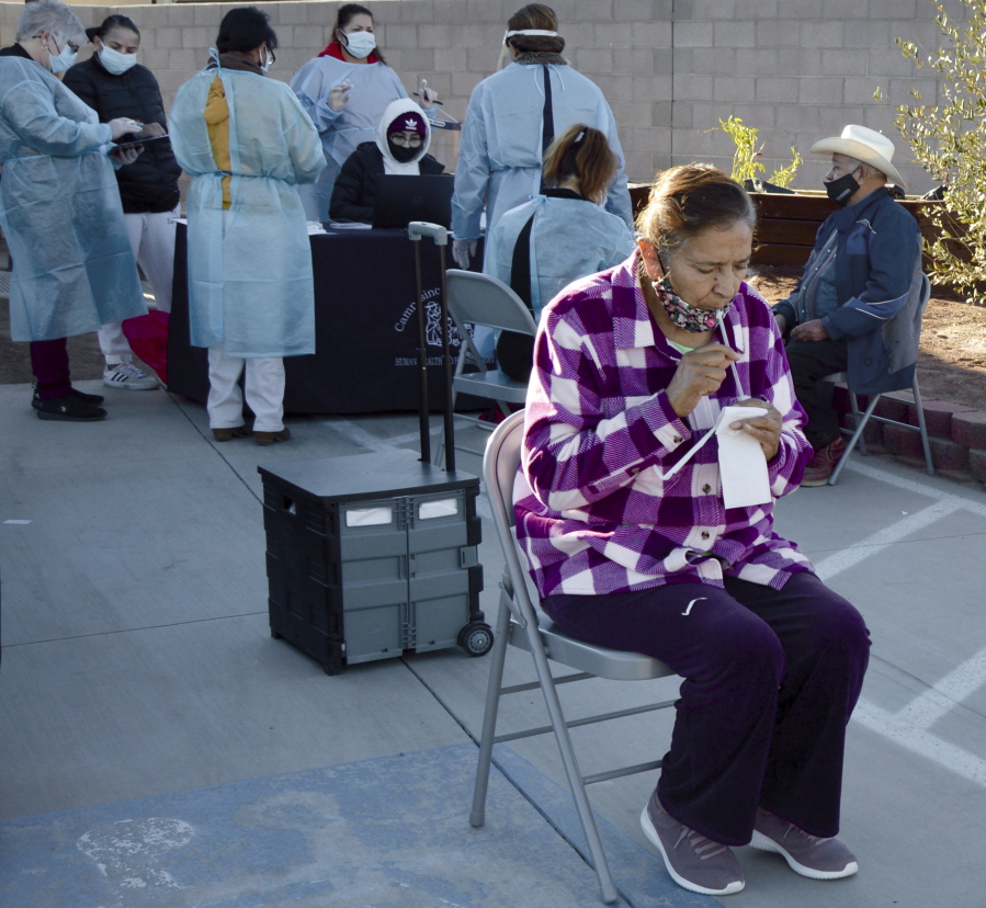 Amalia Ayala, front, a resident of Las Brisas Sunset senior apartment complex in San Luis, Ariz., deposits saliva for her COVID-19 test during the ASU and Equality Health Foundation pilot program on Friday, Jan. 15, 2021. Free saliva tests engineered by Arizona State University&#039;s Biodesign Institute are administered in Yuma County&#039;s small border city of San Luis to disabled and older people living in subsidized housing. The tests have also been given to hundreds of farmworkers.