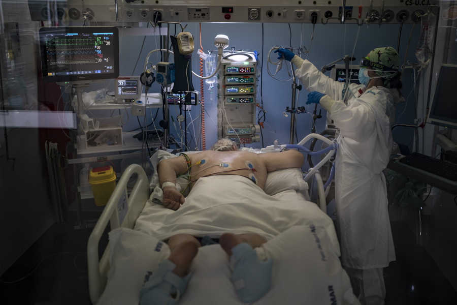 A COVID-19 patient receives treatment in the ICU of the Hospital del Mar, in Barcelona, Spain, Tuesday, Jan. 19, 2021. The unrelenting increase in COVID-19 infections in Spain following the holiday season is again straining hospitals, threatening the mental health of doctors and nurses who have been at the forefront of the pandemic for nearly a year.