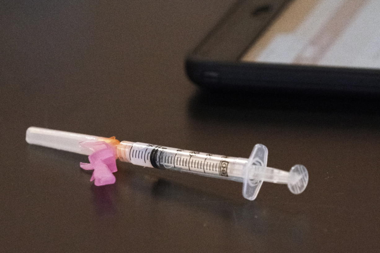 A syringe with the Moderna coronavirus vaccine is displayed at a clinic.