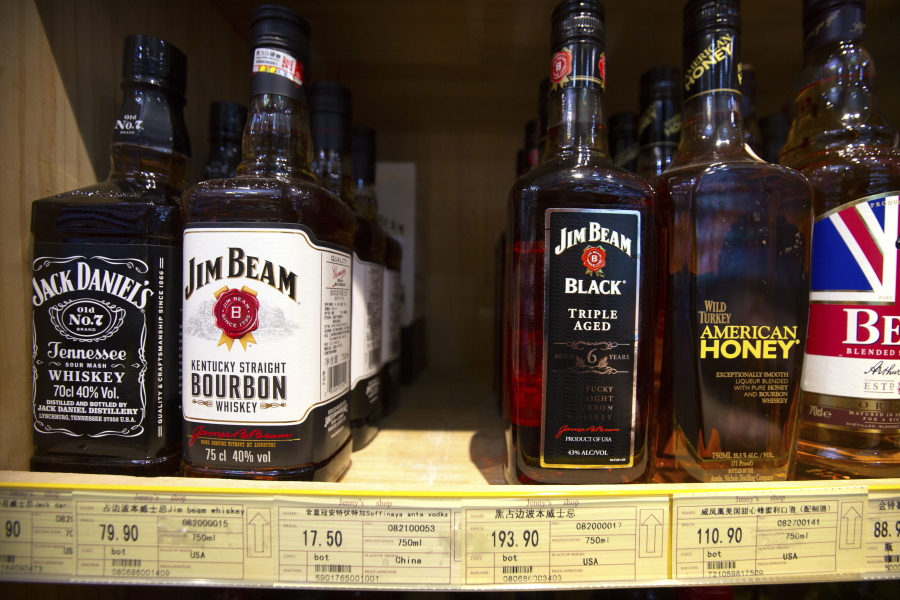 FILE - In this July 7, 2018 file photo whiskeys distilled and bottled in the U.S. are displayed for sale in a grocery store in Beijing.  American whiskey absorbed some setbacks but showed resilience in the face of COVID-related clampdowns on bars and restaurants as liquor sales benefited from enduring demand for a good stiff drink.  Despite plunging sales from bars and restaurants, the American whiskey sector still rang up increased revenues in 2020.
