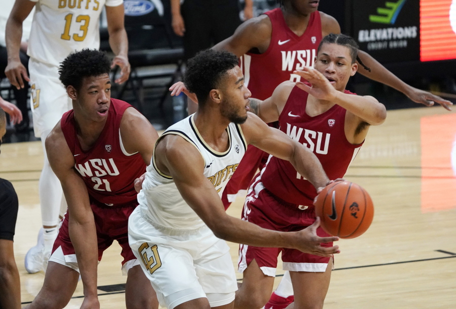 Colorado guard D&#039;Shawn Schwartz, front, passes the ball as Washington State center Dishon Jackson, left, and forward DJ Rodman defend during the second half of an NCAA college basketball game Wednesday, Jan. 27, 2021, in Boulder, Colo.