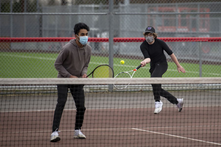 Mountain View senior Nathaniel John, left, watches his Skyview opponents while senior Bryce Penick hits a return in a 3A/4A Greater St. Helens League boys tennis match on Monday at Union High School. Monday was the first time in 333 days that local high school sports held competitions.