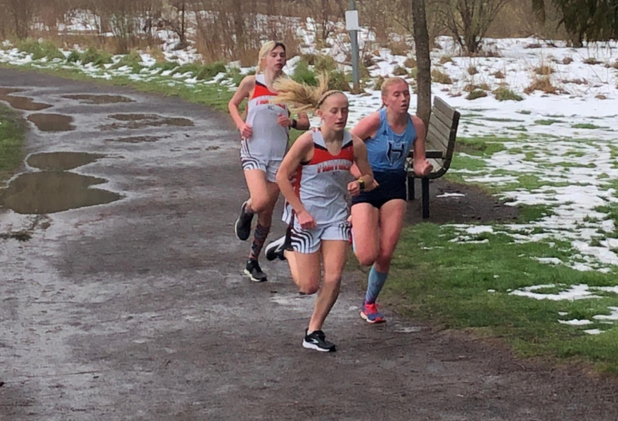 Washougal freshman Elle Thomas runs ahead of Hockinson senior Allyson Peterson and Washougal sophomore Sydnee Boothby during a 5,000 meter race Thursday at Hockinson Meadows Community Park. Thomas won in 18 minutes, 57 seconds.