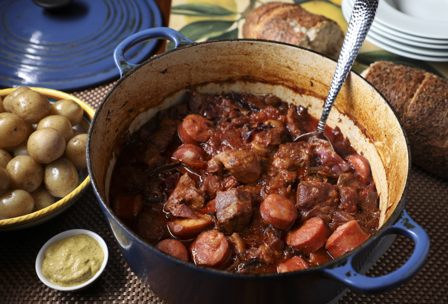 Pork simmers in a Dutch oven or slow cooker with cabbage and sauerkraut. Kielbasa is added near the end of cooking.