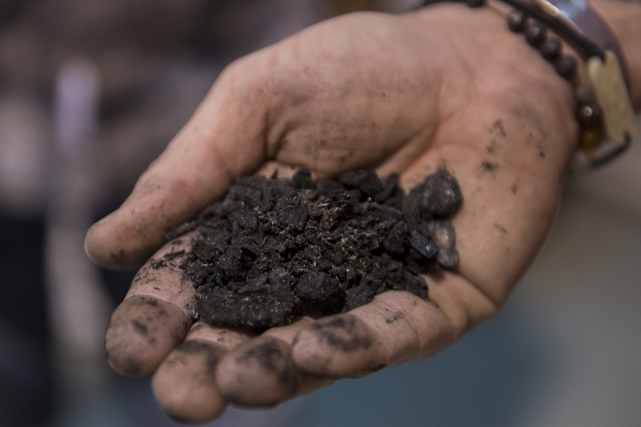 Chris Smith of Backwoods Biochar displays a handful of biochar from supplier Locoal. Backwoods Biochar sells biochar-infused soil for cannabis plants. Biochar is a high-carbon charcoal byproduct of an energy production process called biomass gasification.