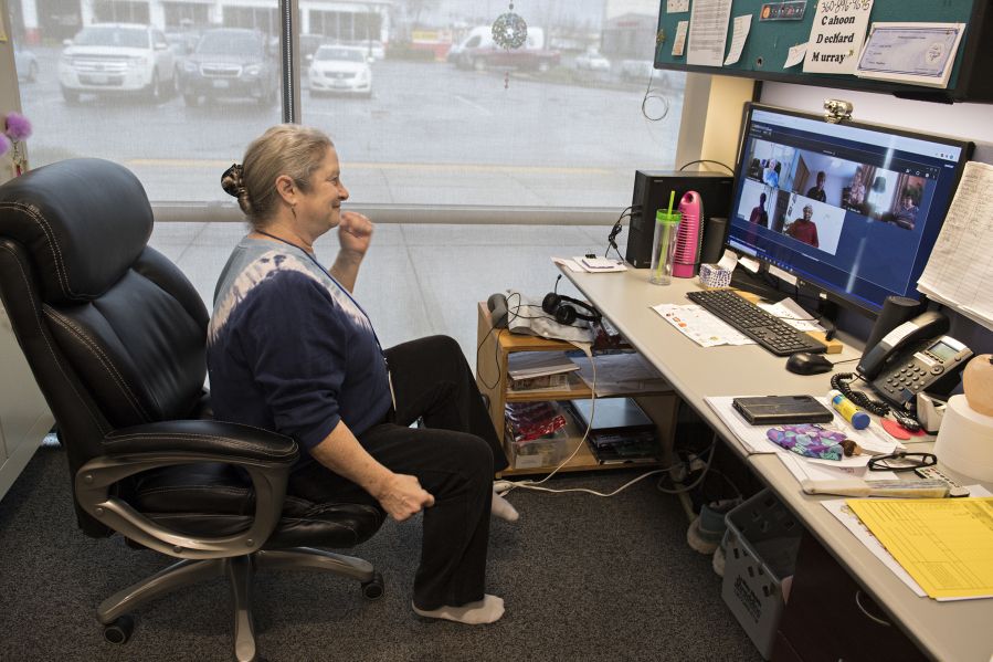 Laura Fitzgibbon, activities director for CDM Caregiving Services, joins clients in some exercises from her office chair via computer during a remote workout in Vancouver. Before the COVID-19 pandemic, Fitzgibbon saw clients in person, but now she has to see them virtually.