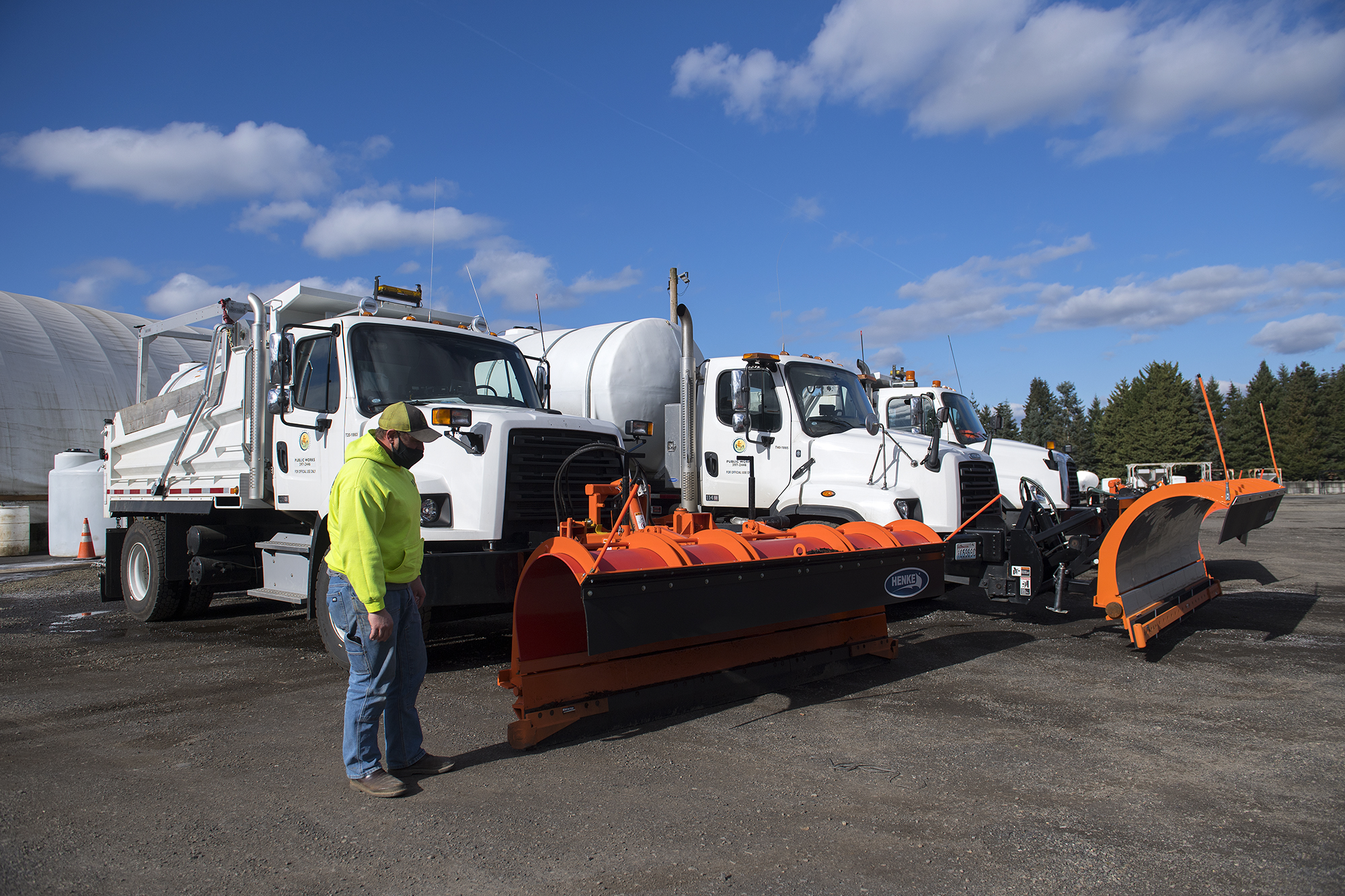 LEADOPTION Richard Harris of the Clark County Public Works Department walks past trucks used for plowing and deicing streets as crews get ready for the possibility of snow accumulation Wednesday afternoon, Feb. 10, 2021.