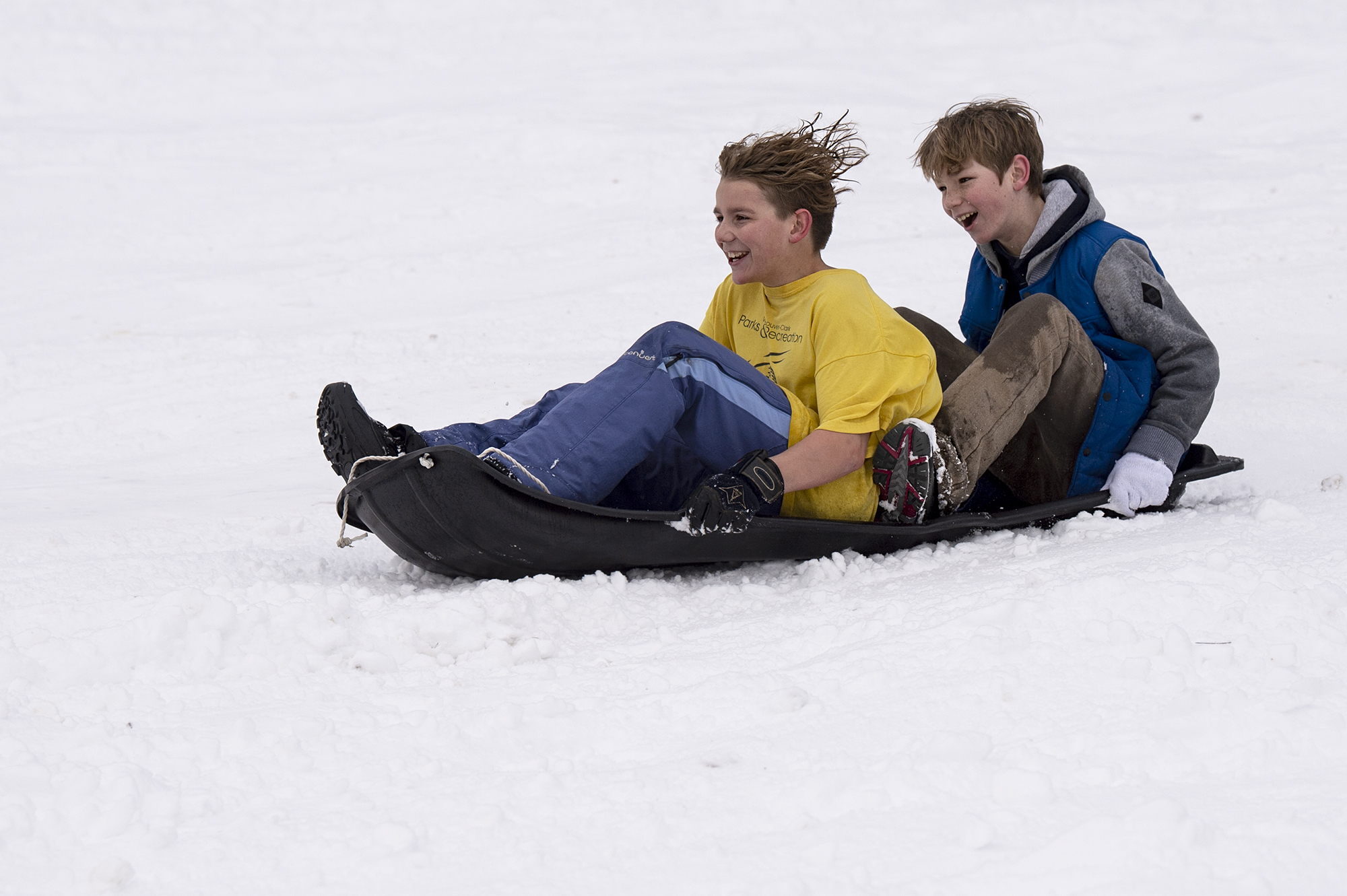 Kids laugh as they speed down a hill on a sled on Saturday morning, February 13, 2021, at Sorenson Park in Felida. Snow accumulated in amounts up to 10 inches through Friday night and Saturday morning in Clark County.