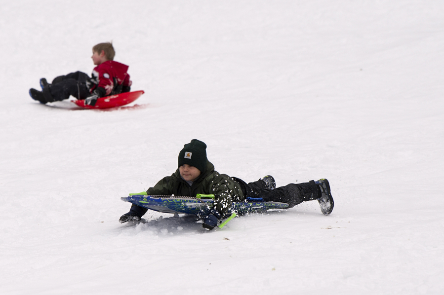 Madden Dreier, 6, slides headfirst on Saturday morning while playing in the snow at Sorenson Park in Felida.