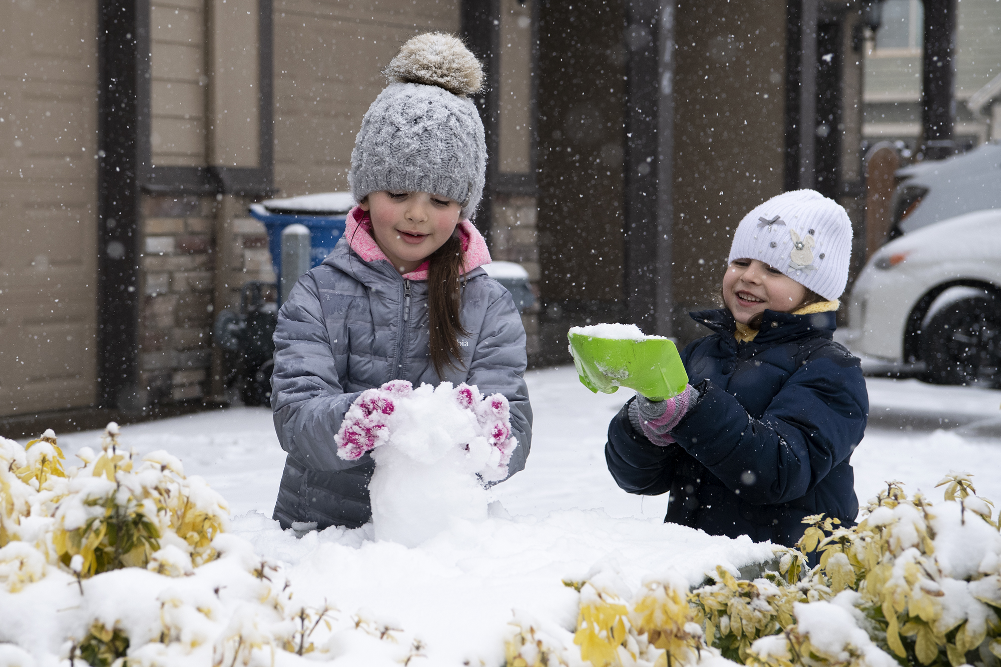 Emilya, 6, and Katerina, 5, play in the snow on Friday, February 12, in front of their home in the Minnehaha neighborhood. Snow continued to accumulate Friday morning as the winter storm persisted.