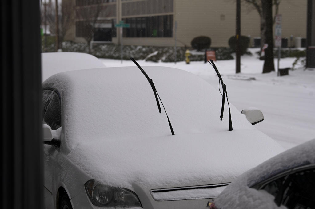 Windshield wipers rise through a couple of inches of snow on a parked car on Friday afternoon, February 12, 2021 in downtown Vancouver.