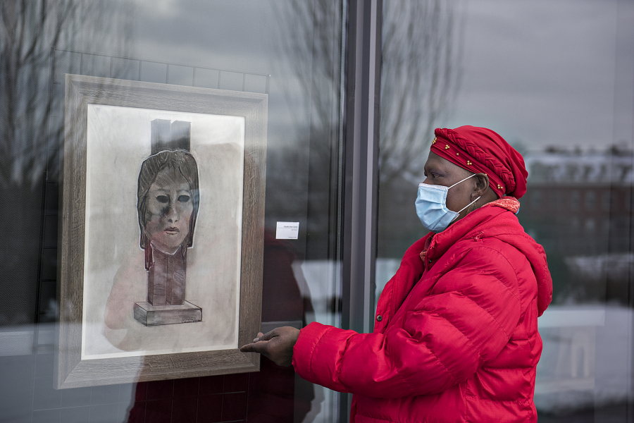 Artist Claudia Carter looks over a piece titled, &quot;Self Portrait,&quot; in the side window exhibit at Vancouver Community Library in Vancouver. Carter has been putting on a Black History Month installation for four years. In February 2020, she was diagnosed with cancer and her goal was to live until at least February 2021 for one last installation.