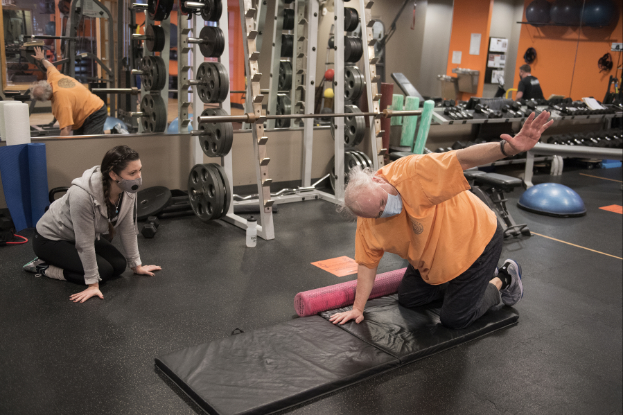 Alicia Rose, left, personal trainer and group fitness instructor at Northwest Personal Training, works with Cliff Miller of Vancouver in downtown Vancouver. Gyms are now open for 25 percent capacity for in-person training.
