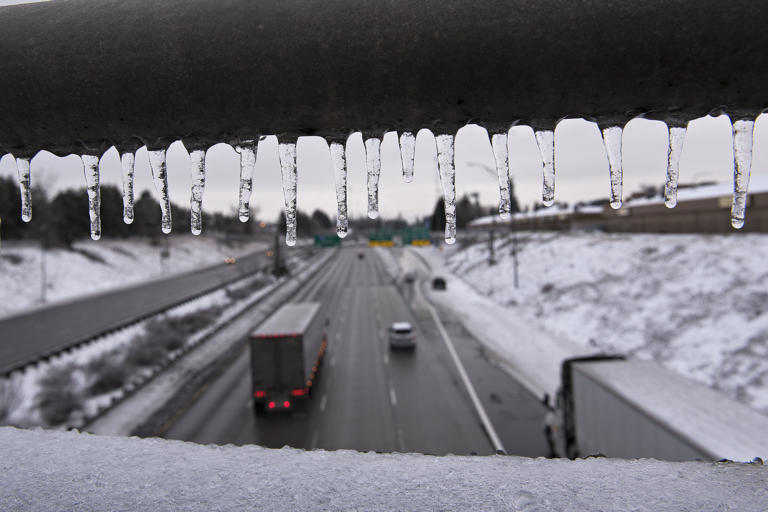 Icicles hang from the railing of a bridge as sporadic traffic flows smoothly in the northbound lane of Interstate 205 following an ice storm Monday morning, Feb. 15, 2021.