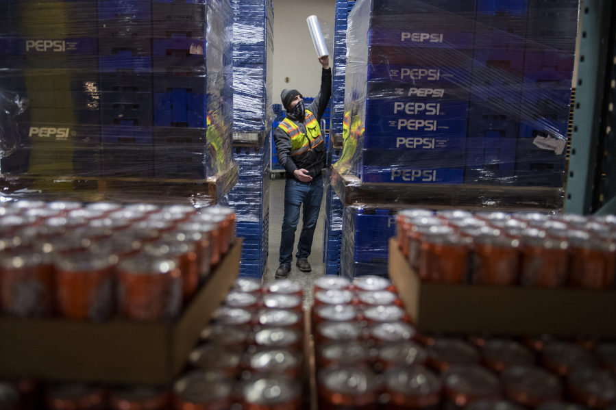 Keith Bunn prepares empty containers for beverage refills at Corwin Distributing in Ridgefield. Corwin Distributing Co. expects to suffer if a new tax on sweetened beverages, introduced in a Washington Senate committee meeting this week, is passed into law.