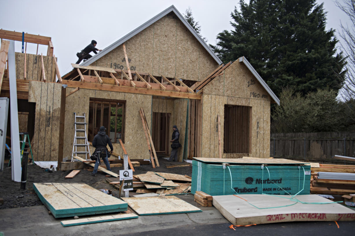 Workers lend a hand to a house under construction on Jan. 27 in the Felida Overlook neighborhood.