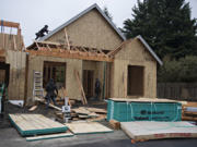 Workers lend a hand to a house under construction on Jan. 27 in the Felida Overlook neighborhood.