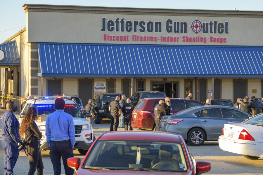 Bystanders react at the scene of a multiple fatality shooting at the Jefferson Gun Outlet in Metairie, La., Saturday, Feb. 20, 2021. A suspect fatally shot two people at a gun store in a suburb of New Orleans on Saturday afternoon, and the shooter also died during gunfire as others engaged the suspect both inside and outside the outlet, authorities said.