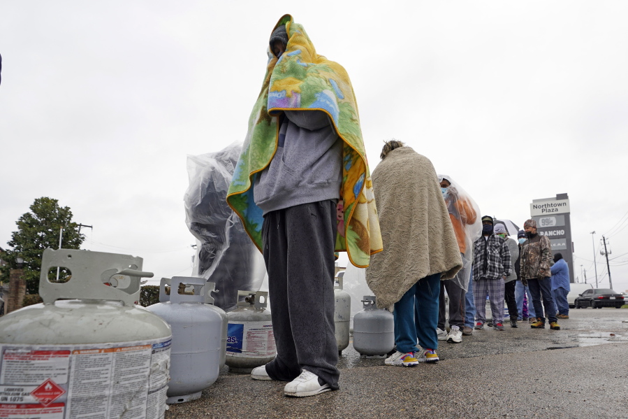 Carlos Mandez waits in line to fill his propane tanks Wednesday, Feb. 17, 2021, in Houston. Customers had to wait over an hour in the freezing rain to fill their tanks. Millions in Texas still had no power after a historic snowfall and single-digit temperatures created a surge of demand for electricity to warm up homes unaccustomed to such extreme lows, buckling the state&#039;s power grid and causing widespread blackouts. (AP Photo/David J.