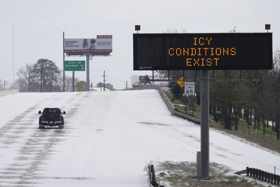A truck drives past a highway sign Monday, Feb. 15, 2021, in Houston. A frigid blast of winter weather across the U.S. plunged Texas into an unusually icy emergency Monday that knocked out power to more than 2 million people and shut down grocery stores and dangerously snowy roads. (AP Photo/David J.