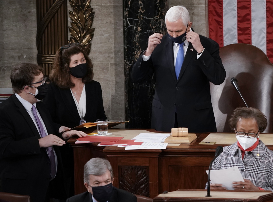 In this Jan. 6, 2021, photo, Senate Parliamentarian Elizabeth MacDonough, left, works beside Vice President Mike Pence during the certification of Electoral College ballots in the presidential election, in the House chamber at the Capitol in Washington. Shortly afterward, the Capitol was stormed by rioters determined to disrupt the certification. MacDonough has guided the Senate through two impeachment trials, vexed Democrats and Republicans alike with parliamentary opinions and helped rescue Electoral College certificates from a pro-Trump mob ransacking the Capitol. (AP Photo/J.