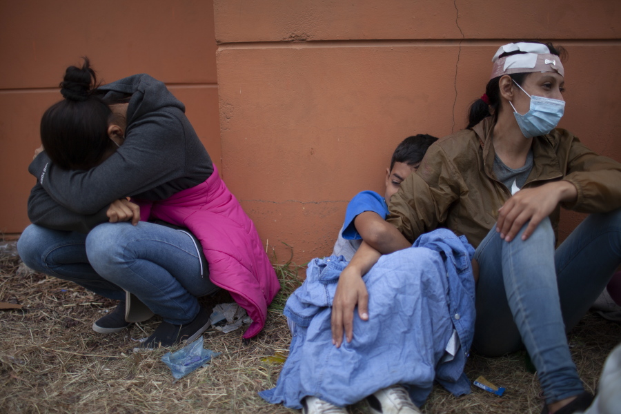 FILE - In this Jan. 17, 2021, file photo injured women, part of a Honduran migrant caravan in their bid to reach the U.S. border, weep as they sit on the side of a highway after clashing with Guatemalan police and soldiers in Vado Hondo, Guatemala, Guatemala. U.S. Federal law allows immigrants facing credible threats of persecution or violence in their home country to seek U.S. asylum.