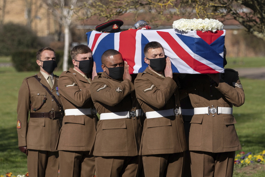 The coffin of Captain Sir Tom Moore is carried by members of the Armed Forces during his funeral, at Bedford Crematorium, in Bedford, England, Saturday. Tom Moore, the 100-year-old World War II veteran who captivated the British public in the early days of the coronavirus pandemic with his fundraising efforts died Feb. 2.
