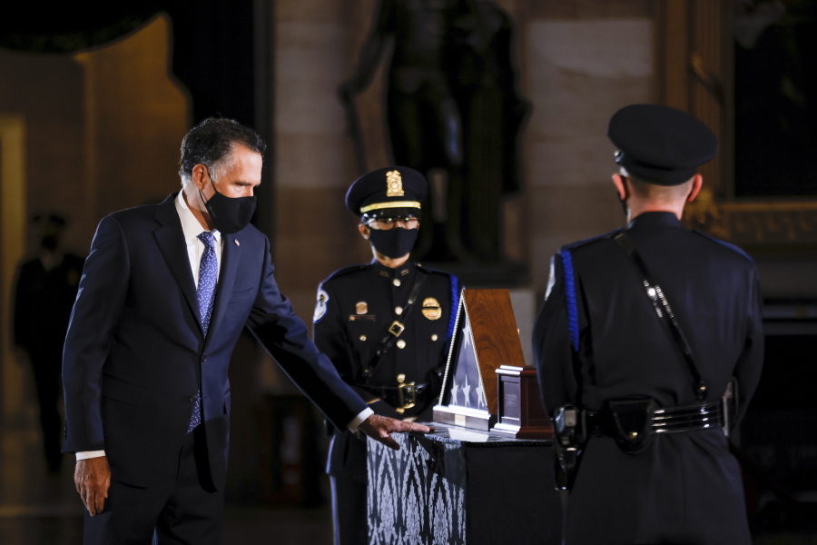 Sen. Mitt Romney, R-Utah, pays respect to the late U.S. Capitol Police officer Brian Sicknick as an urn with his cremated remains lies in honor on a black-draped table at the center of the Capitol Rotunda, Wednesday, Feb. 3, 2021, in Washington.