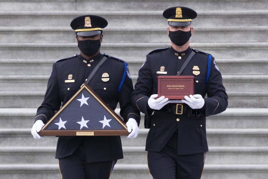 An honor guard carries an urn with the cremated remains of U.S. Capitol Police officer Brian Sicknick down the steps of the U.S. Capitol, Feb. 3 in Washington.