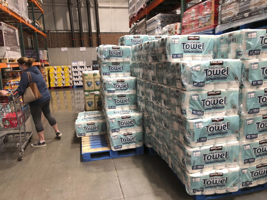 A shopper loads her basket next to a display of paper towels in a Costco warehouse in this photograph taken Wednesday, Nov. 18, 2020, in Sheridan, Colo.  U.S. consumer prices edged up 0.2% in November as a rise in energy costs and variety of other items offset a drop in food costs. The Labor Department reported on Thursday, Dec. 10, that the gain in the consumer price index followed an unchanged reading in October and matched the 0.2% September advance.