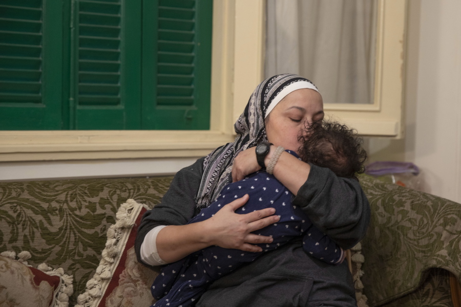 Foster mother Yasmina El Habbal kisses with her 7-month-old daughter Ghalia, at their apartment in Cairo, Egypt, Wednesday, Jan. 20, 2021.  Egyptians who have taken in children under the Islamic system of guardianship known as Kafala are turning to social media to raise awareness as part of a push to provide orphans with permanent families.