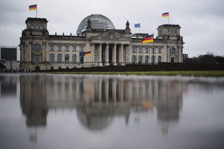 FILE - In this Tuesday, March 10, 2020 file photo, the German parliament building Reichtstag reflected in a puddle in Berlin. A German man has been charged with espionage for allegedly passing information on properties used by the German parliament to Russian military intelligence.
