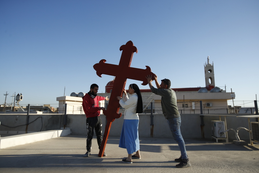 Iraqi Christians place a cross on a church in Qaraqosh, Iraq, on Feb. 22.