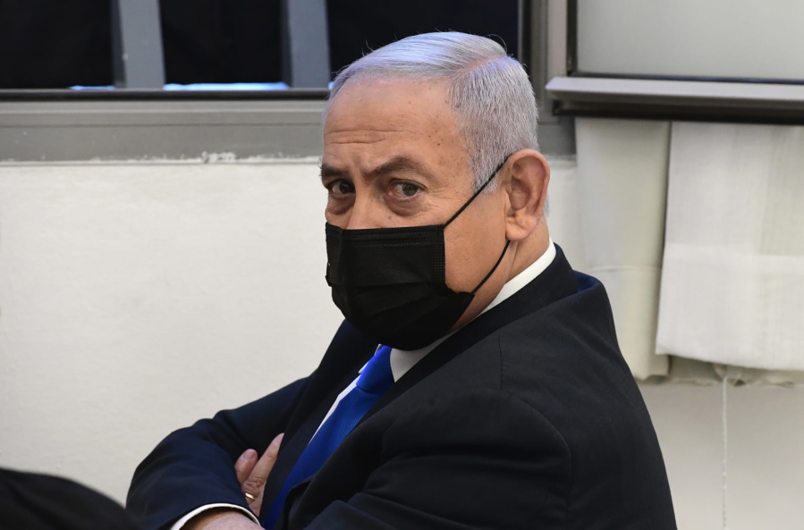 Israeli Prime Minister Benjamin Netanyahu looks on prior to a hearing at the district court in Jerusalem, Monday, Feb. 8, 2021. Netanyahu appeared in a Jerusalem courtroom Monday to respond formally to corruption charges just weeks before national elections in which he hopes to extend his 12-year rule.