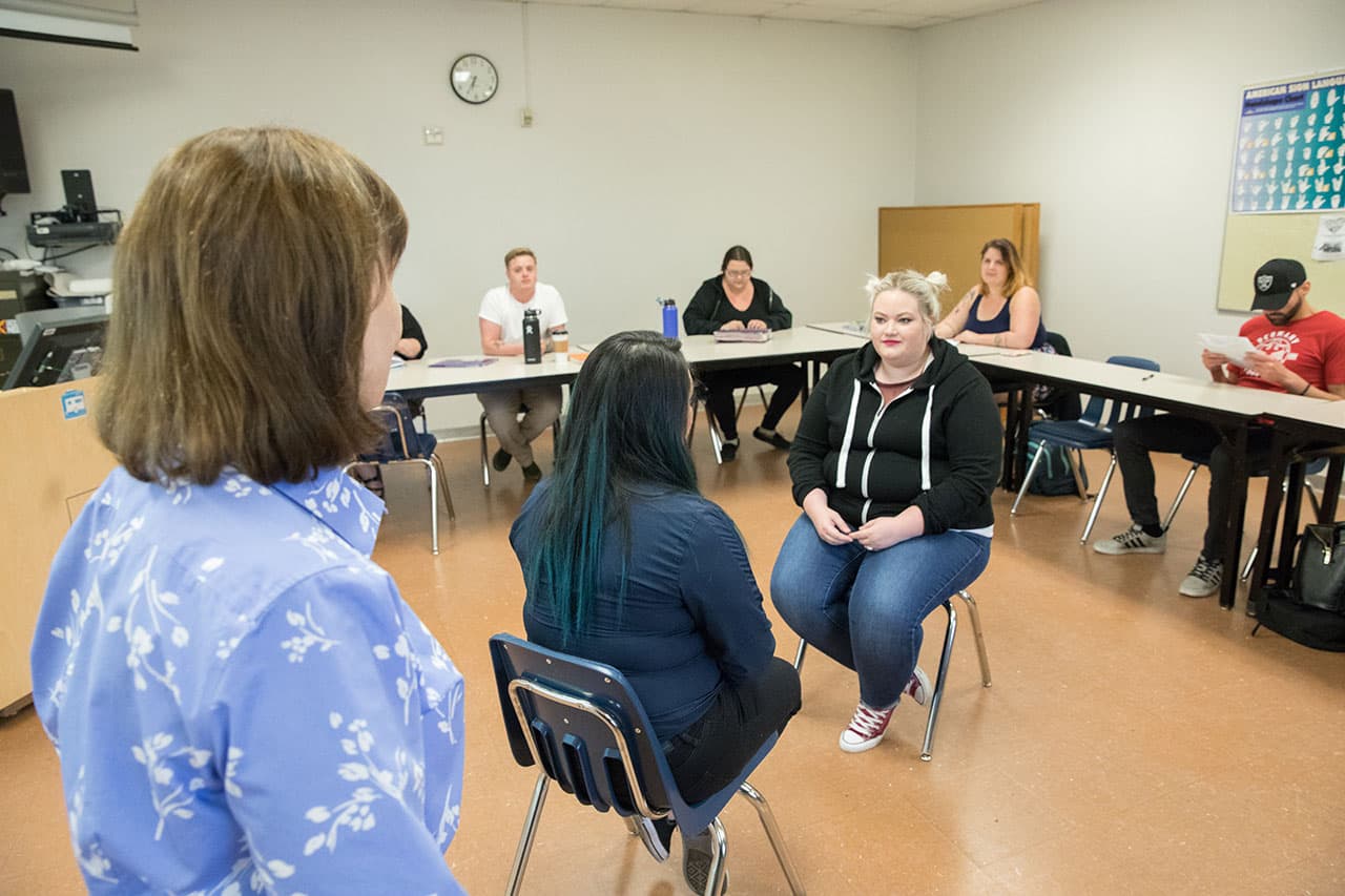 Clark College students enrolled in the Bachelor of Applied Science in Human Services program practice counseling techniques in the classroom while Professor Marcia Roi, bottom left, observes and provides guidance.