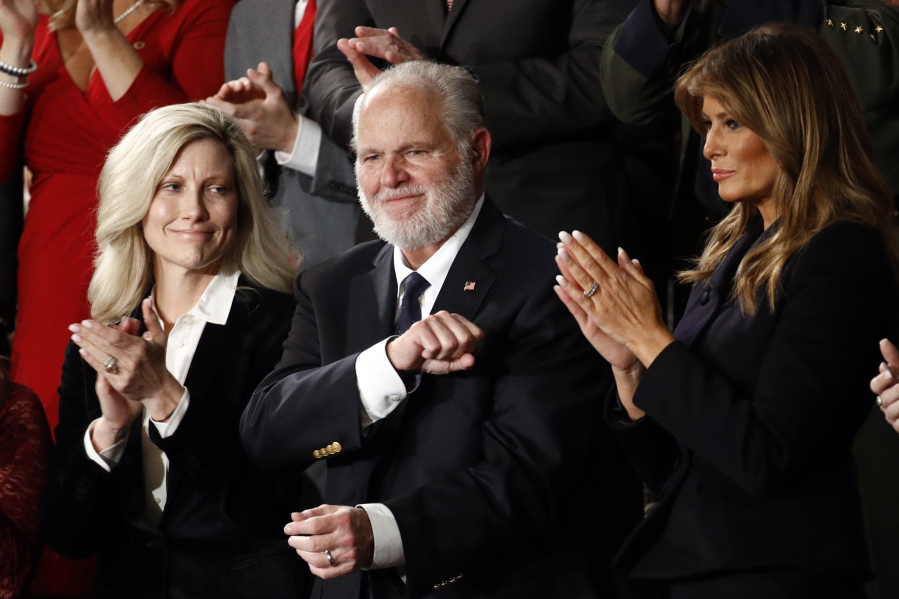 FILE - In this Feb. 4, 2020 file photo, Rush Limbaugh reacts as first Lady Melania Trump, and his wife Kathryn, applaud, as President Donald Trump delivers his State of the Union address to a joint session of Congress on Capitol Hill in Washington.  Limbaugh, the talk radio host who became the voice of American conservatism, has died.