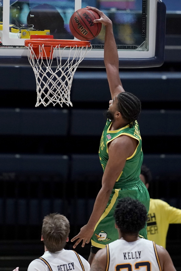 Oregon guard LJ Figueroa, top, dunks against California during the second half of an NCAA college basketball game in Berkeley, Calif., Saturday, Feb. 27, 2021.