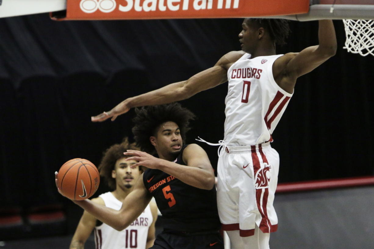 Oregon State guard Ethan Thompson (5) prepares to pass the ball past Washington State center Efe Abogidi (0) during the second half of an NCAA college basketball game in Pullman, Wash., Wednesday, Dec. 2, 2020. Washington State won 59-55.