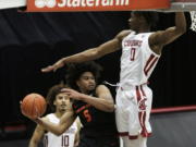 Oregon State guard Ethan Thompson (5) prepares to pass the ball past Washington State center Efe Abogidi (0) during the second half of an NCAA college basketball game in Pullman, Wash., Wednesday, Dec. 2, 2020. Washington State won 59-55.