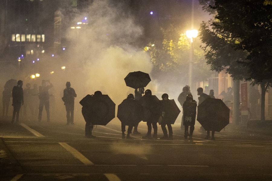 FILE - In this Sept. 18, 2020, file photo, tear gas fills the air during protests in Portland, Ore. An Oregon lawmaker is seeking to ban the use of tear gas and other agents against crowds of people in one of the most sweeping police measures in the country regarding crowd control devices.