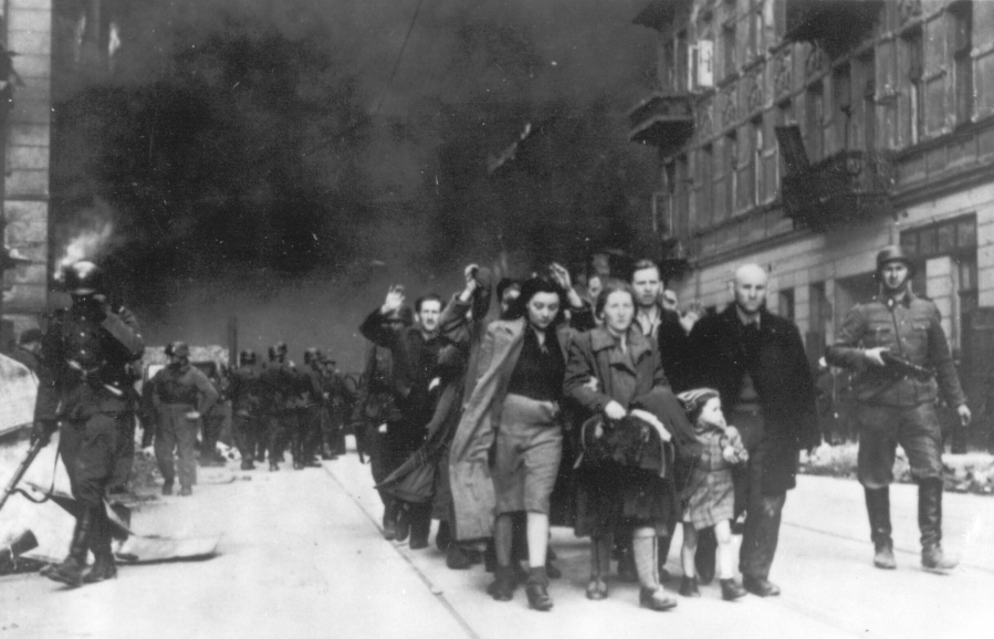 FILE - In this 1943 file photo, a group of Polish Jews are led away for deportation by German SS soldiers during the destruction of the Warsaw Ghetto by German troops after an uprising in the Jewish quarter. A Warsaw court is scheduled to deliver a verdict Tuesday, Feb. 9, 2021 in a closely watched libel case in which Polish national dignity and the independence of Holocaust research are said to be at stake.